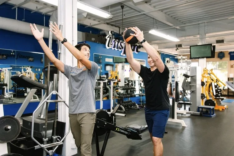 A patient working through a guided overhead mobility exercise at On The Run Physical Therapy