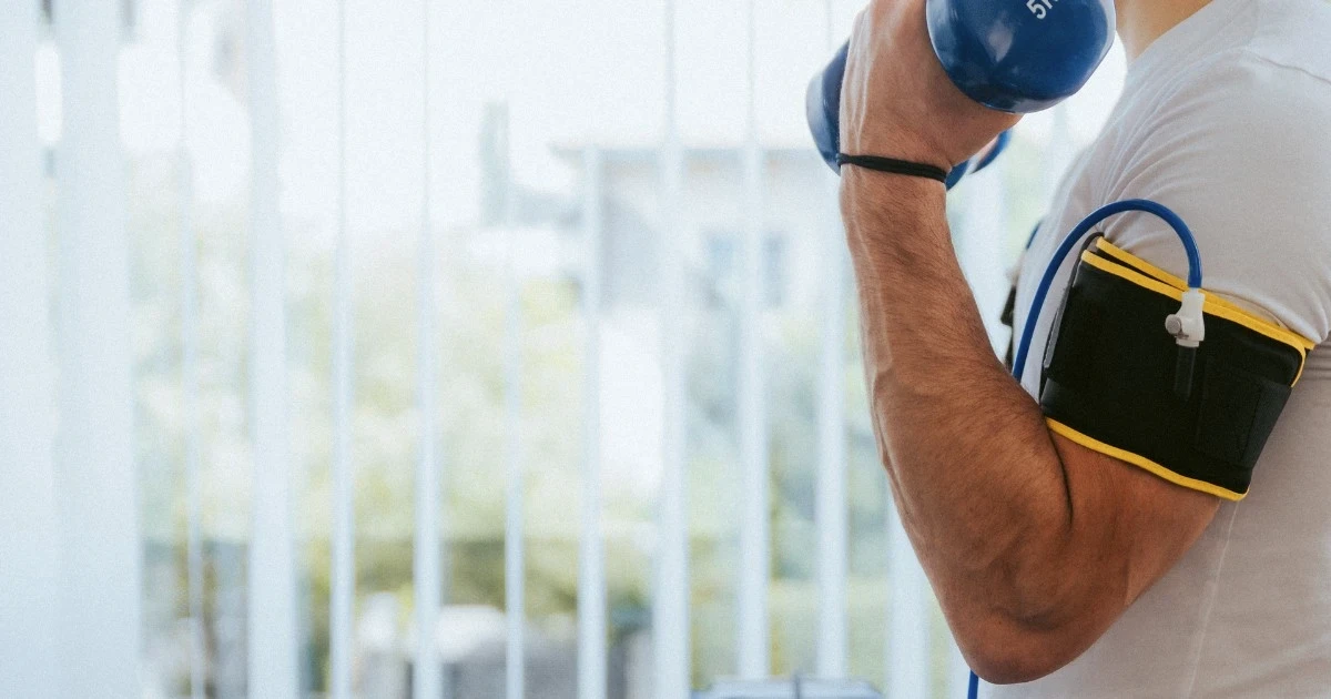 Patient using blood flow restriction bands during a rehab strength session
